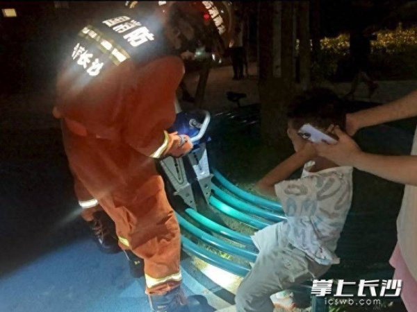 长红配资 小男孩脚卡环形长凳，消防员成功处置